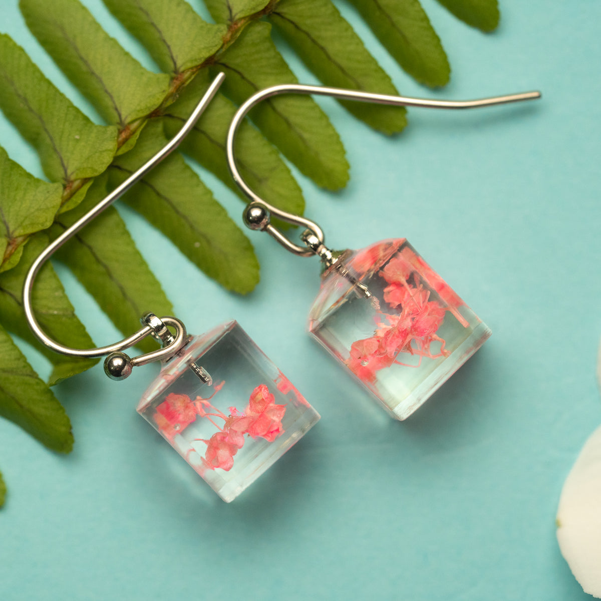 Soft Radiance: A Pink Flower's Glow in a Light Box Earring