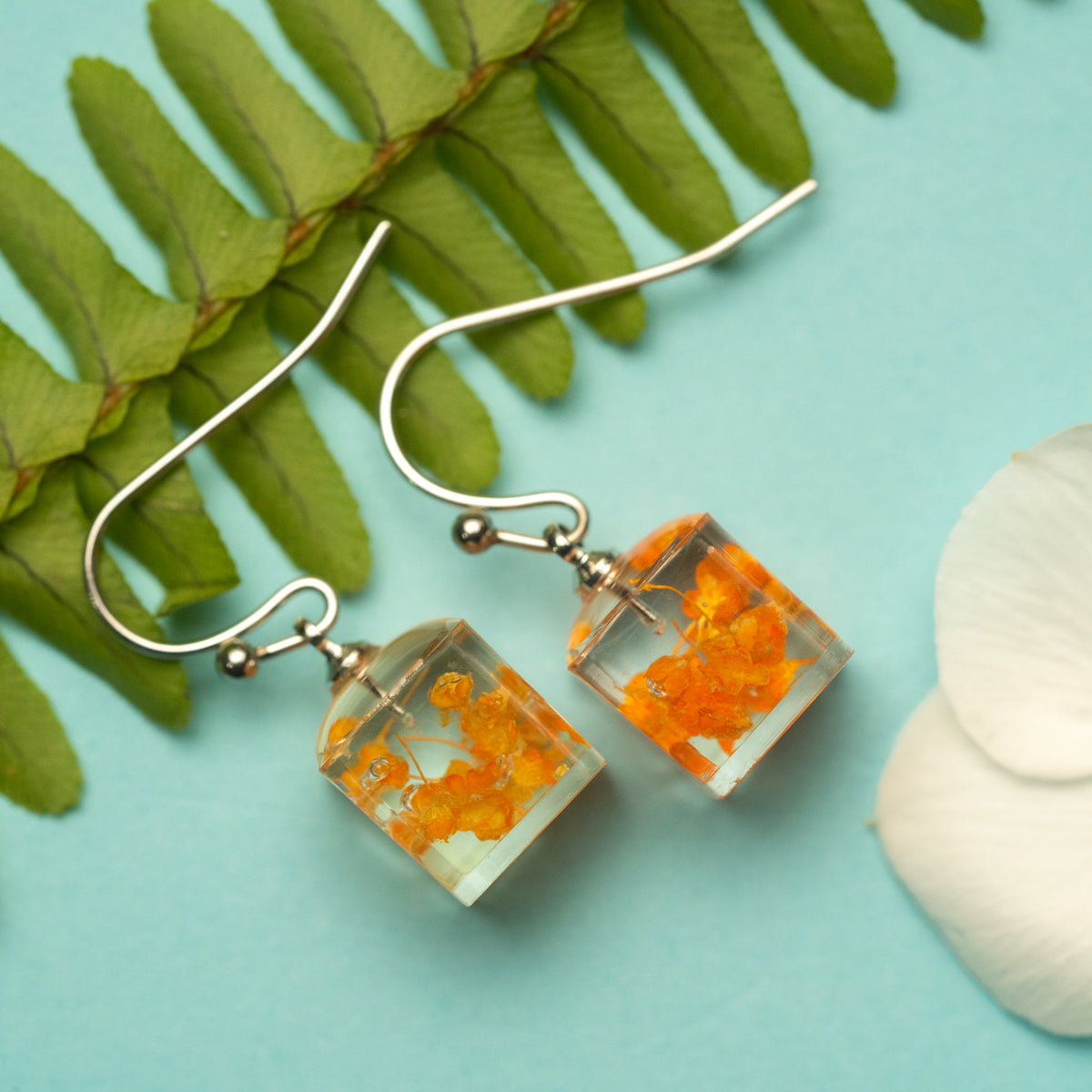 Warm Embrace: An Orange Flower’s Radiance in a Light Box Earring